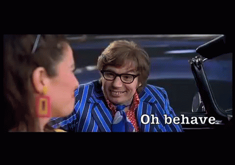 A Man In A Blue Suit And Tie Is Talking To A Woman In A Car And The Words Oh Behave Are Visible GIF