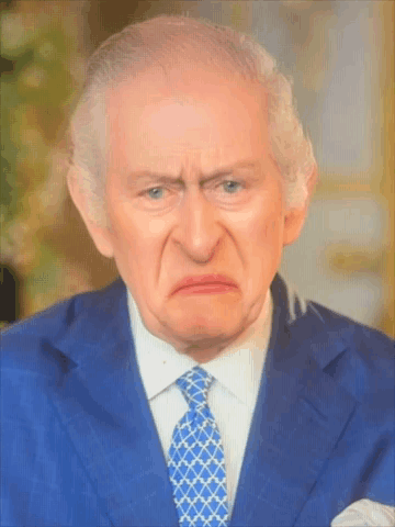 A Man In A Blue Suit And Tie Making A Funny Face GIF