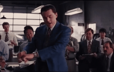 A Man In A Blue Suit And Tie Stands In Front Of A Group Of Men In Suits And Ties . GIF