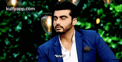 A Man In A Blue Suit And White Shirt Is Talking To Someone . GIF