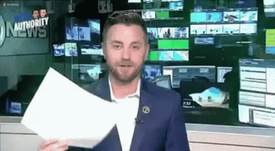 A Man In A Blue Suit Is Holding A Piece Of Paper In Front Of A Wall With A Sign That Says Authority News . GIF