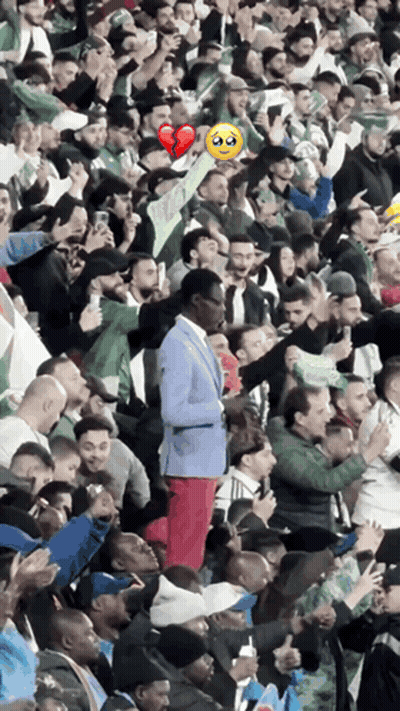 A Man In A Blue Suit Is Standing In A Crowd Of People GIF