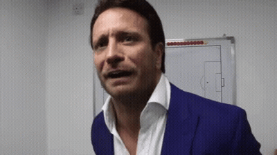 A Man In A Blue Suit Is Standing In Front Of A White Board With A Soccer Field Drawn On It GIF