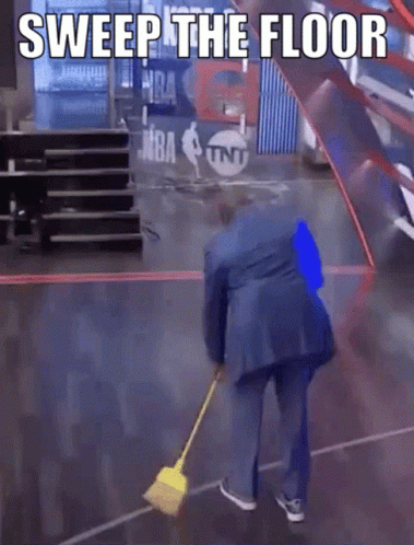 A Man In A Blue Suit Is Sweeping The Floor With A Yellow Broom GIF