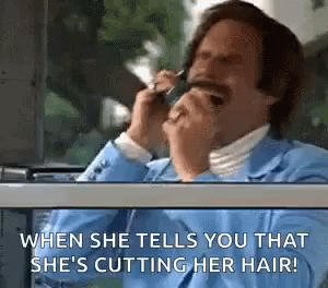 A Man In A Blue Suit Is Talking On A Cell Phone While Looking Out The Window . GIF