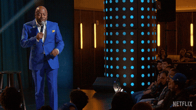 A Man In A Blue Suit Stands In Front Of A Crowd With The Words " Everybody Gets A Therapist " GIF