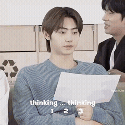 A Man In A Blue Sweater Is Holding A Piece Of Paper And Thinking . GIF