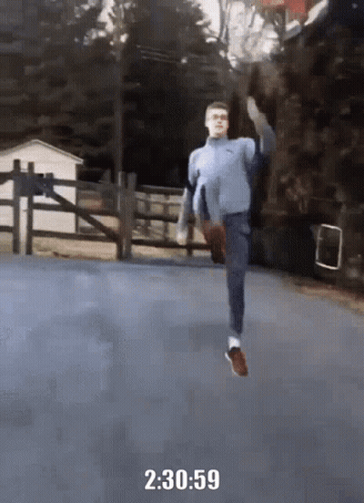 A Man In A Blue Sweater Is Running On A Road With The Time Of 2 : 30 : 59 GIF