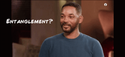 A Man In A Blue Sweater Is Smiling With The Words " Entanglement " Below Him GIF