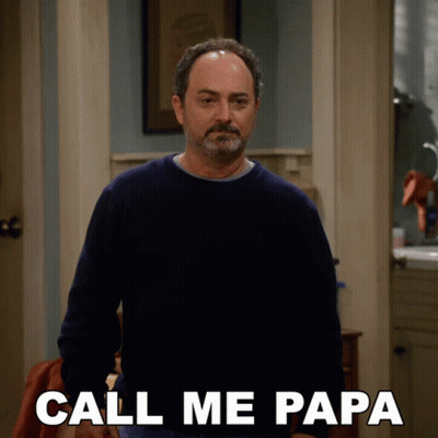 A Man In A Blue Sweater Is Standing In A Hallway And Says Call Me Papa GIF