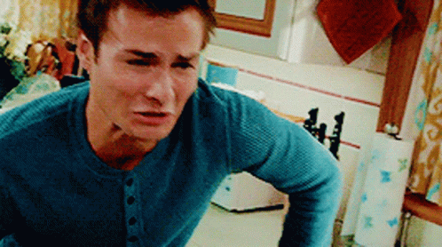 A Man In A Blue Sweater Is Standing In A Kitchen GIF