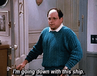 A Man In A Blue Sweater Is Standing In Front Of A Door And Saying I 'M Going Down With This Ship GIF