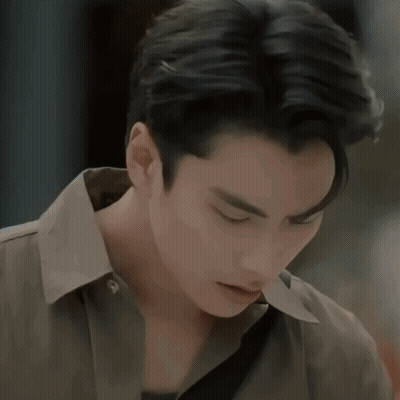 A Man In A Blue Sweater Looks At Another Man In A Brown Jacket GIF
