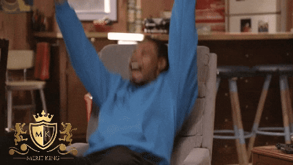 A Man In A Blue Sweater Sits In A Chair With His Arms In The Air And A Merit King Logo In The Corner GIF