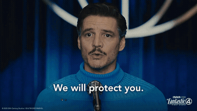 A Man In A Blue Sweater Stands In Front Of A Microphone With The Words We Will Protect You Behind Him GIF