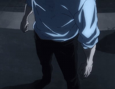 A Man In A Blue Sweater Stands In The Dark GIF