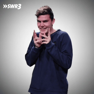 A Man In A Blue Sweatshirt Is Clapping In Front Of A Swr3 Sign GIF