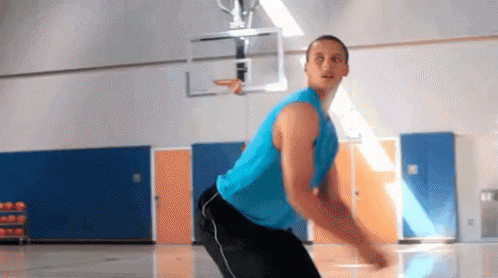 A Man In A Blue Tank Top And Black Pants Is Playing Basketball On A Court . GIF