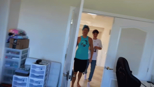 A Man In A Blue Tank Top Is Standing In A Room With The Words Why Do You Look GIF