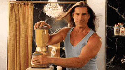 A Man In A Blue Tank Top Is Using A Blender In A Bathroom GIF