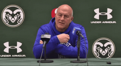 A Man In A Blue Under Armour Sweatshirt Is Sitting At A Table GIF