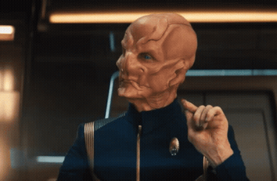 A Man In A Blue Uniform Has A Star Trek Logo On His Jacket GIF