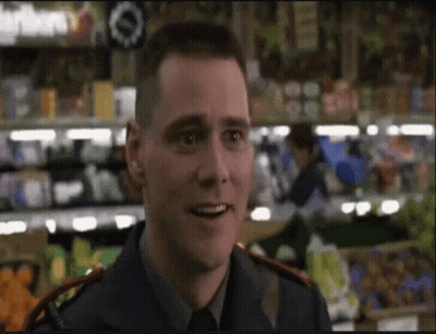 A Man In A Blue Uniform Is Smiling In Front Of A Grocery Store GIF