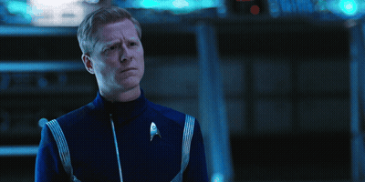 A Man In A Blue Uniform With A Star Trek Logo On The Front GIF