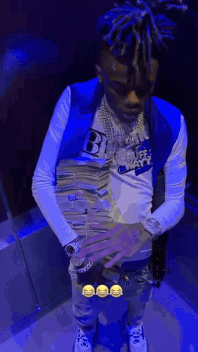 A Man In A Blue Vest Is Holding A Stack Of Money In His Hands . GIF