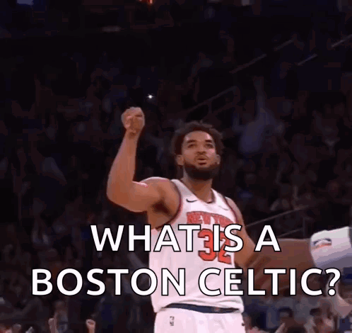 A Man In A Boston Celtic Jersey Holds His Fist Up In The Air GIF