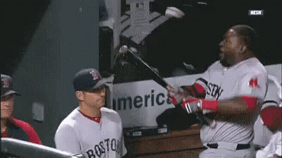 A Man In A Boston Jersey Is Swinging A Bat At Another Man GIF