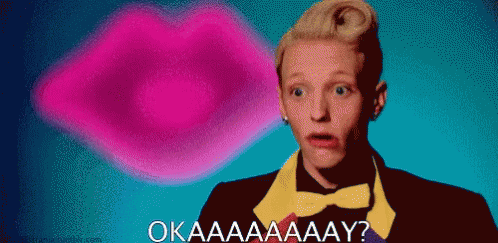 A Man In A Bow Tie Says Okaaaaaay In Front Of A Pink Lip GIF