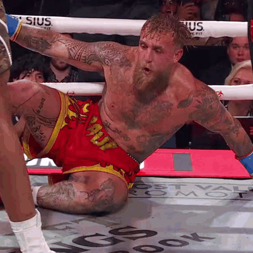 A Man In A Boxing Ring Is Wearing Shorts That Say Snoopy GIF