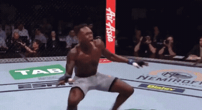 A Man In A Boxing Ring With Ads For Tab And Nemiroff In The Background GIF