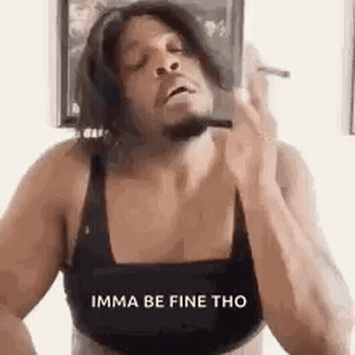 A Man In A Bra Is Smoking A Cigarette While Wearing A Wig . GIF