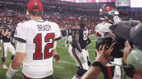 A Man In A Brady 12 Jersey Stands On The Field GIF