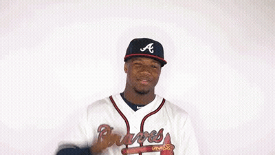 A Man In A Braves Jersey Flexes His Muscles GIF