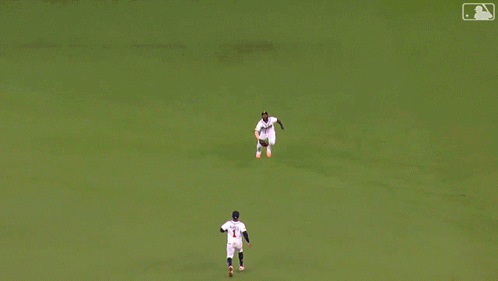 A Man In A Braves Jersey Sits On The Grass Stretching His Legs GIF