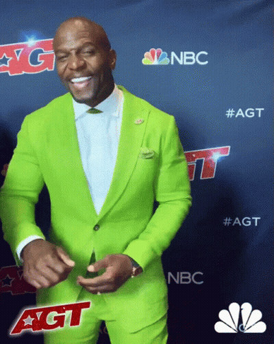 A Man In A Bright Green Suit Is Smiling In Front Of A Nbc Logo GIF