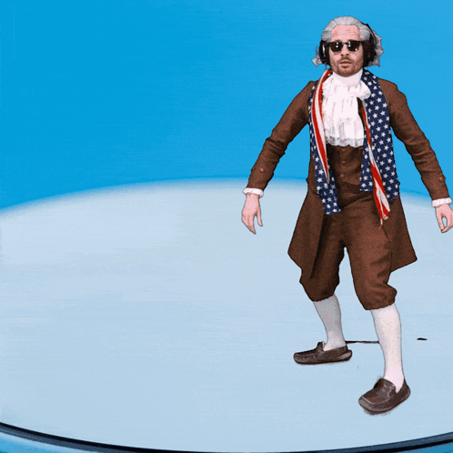 A Man In A Brown Coat With An American Flag Scarf Around His Neck Is Standing On A Blue Surface GIF