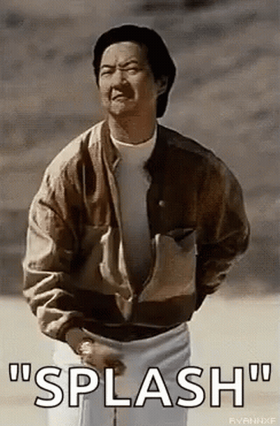 A Man In A Brown Jacket And White Shorts Is Standing In The Dirt And Talking . GIF