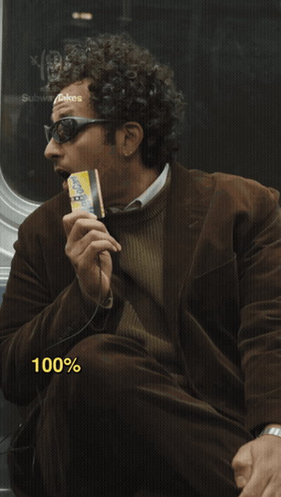 A Man In A Brown Jacket Is Eating A Cheerios Bar GIF