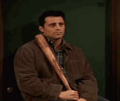 A Man In A Brown Jacket Is Holding A Baseball Bat In His Hand . GIF