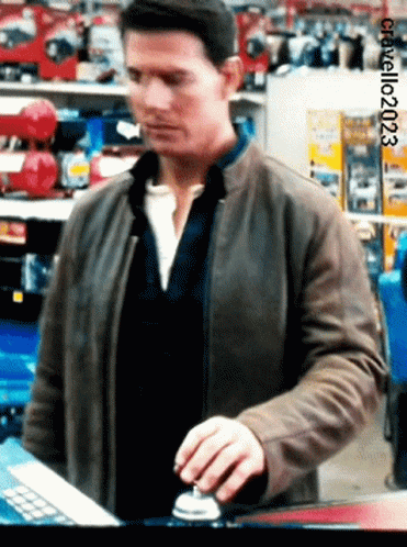 A Man In A Brown Jacket Is Pressing A Button In A Store With The Year 2003 On The Bottom GIF
