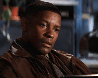 a man in a brown jacket is sitting at a desk