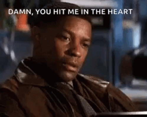 A Man In A Brown Jacket Is Sitting At A Table And Says `` Damn You Hit Me In The Heart '' . GIF