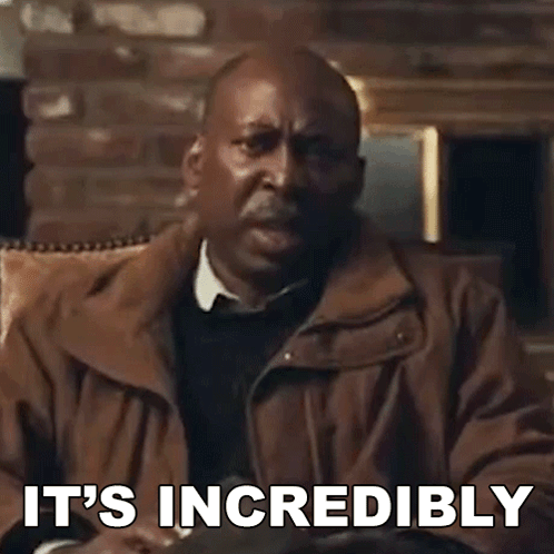 A Man In A Brown Jacket Is Sitting In A Chair With The Words `` It 'S Incredibly '' Written On The Screen . GIF