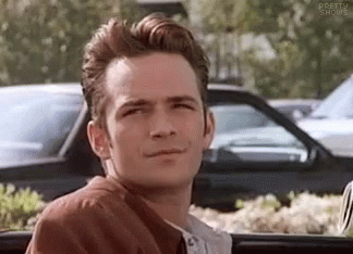 A Man In A Brown Jacket Is Sitting In The Back Seat Of A Car . GIF