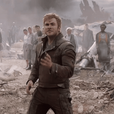 A Man In A Brown Leather Jacket Stands In Front Of A Crowd GIF