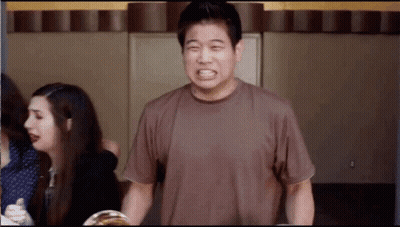 A Man In A Brown Shirt Is Making A Face GIF